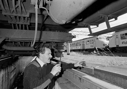 849716 Afbeelding van de controle van een treinstel van de N.S. vanuit een onderhoudsput op het emplacement Dijksgracht ...
